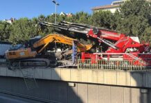 Tırın üzerinden düşen ekskavatör korkuluklarda asılı kaldı