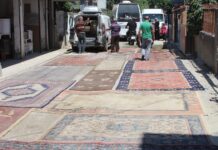 Asfaltlanmayan sokağın tozundan rahatsız olan mahalleli yola halı serdi